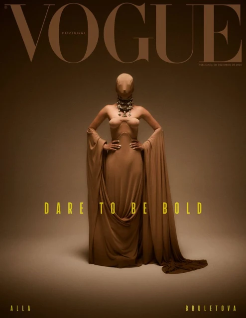 Vogue Portugal cover with model wearing a draped brown dress and large jeweled necklace, posing in a photo studio with a light brown backdrop.