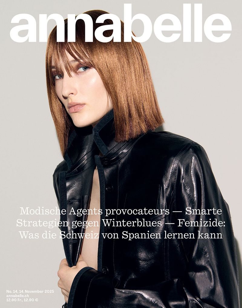 Magazine cover featuring a brown-haired woman in a black leather jacket with a neutral expression against a light background.