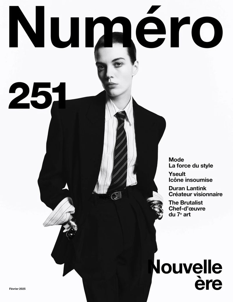 Black and white fashion magazine cover featuring a person in a suit and tie against a white background with large text.