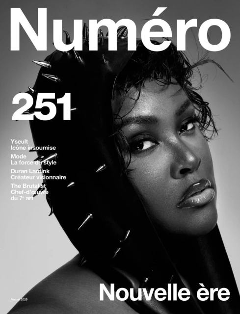 Magazine cover featuring a black and white portrait of a woman wearing a spiked hood. The magazine title is 'Numéro' and 'Nouvelle ère'.