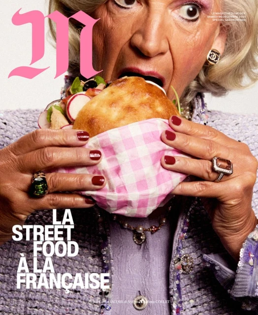 Magazine cover featuring an elderly woman in a lilac outfit eating a large sandwich, adorned with jewelry and a Chanel earring.