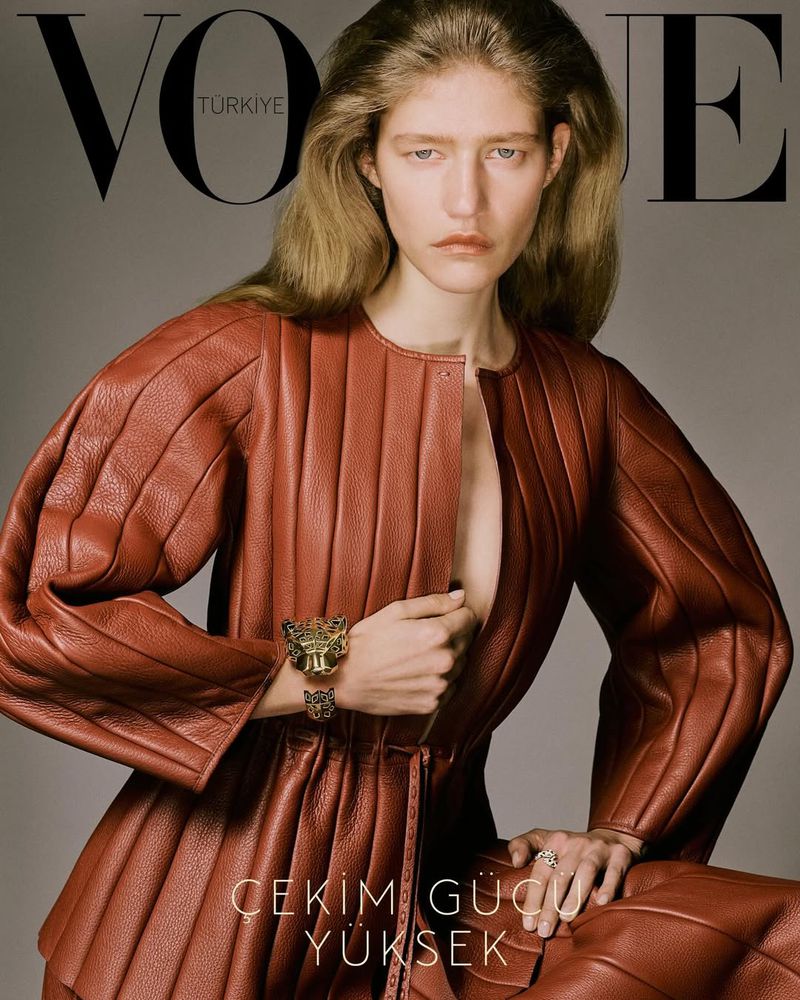 Vogue Turkiye cover featuring a blonde female model in a red leather outfit with metallic bracelets and a neutral expression.