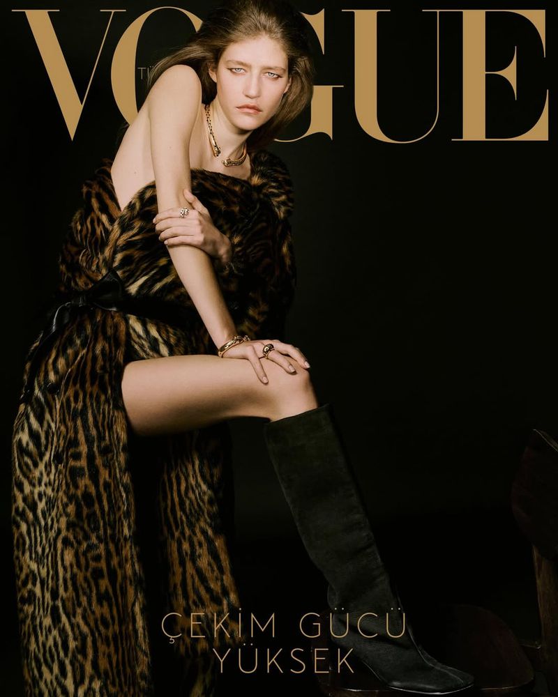 Vogue cover featuring a young woman in a leopard print coat and black boots posing against a dark background with the Vogue logo.