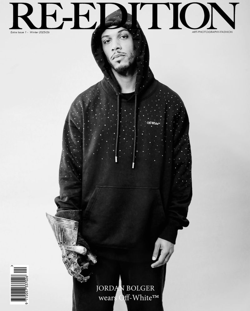 Black and white magazine cover featuring a male model with a prosthetic metal hand wearing an Off-White hoodie with star patterns.