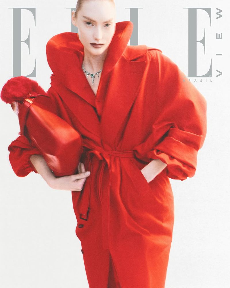 Fashion editorial featuring a woman in a red coat holding a red purse, posing against a white background, for an Elle magazine cover.
