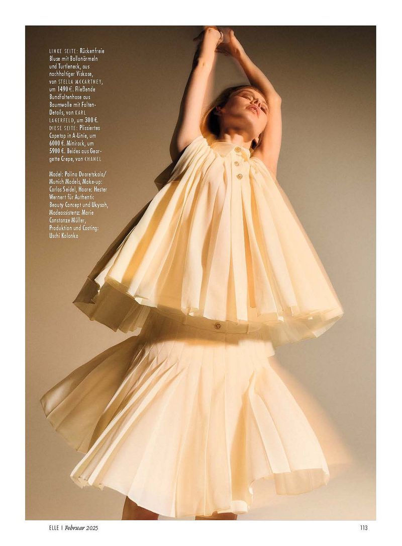 Fashion editorial shot of a woman in a light yellow dress, arms raised, against a neutral backdrop, showcasing contemporary women's fashion.