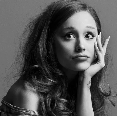 Portrait of Ariana Grande resting her chin on her hand with expressive eyes for Interview Magazine