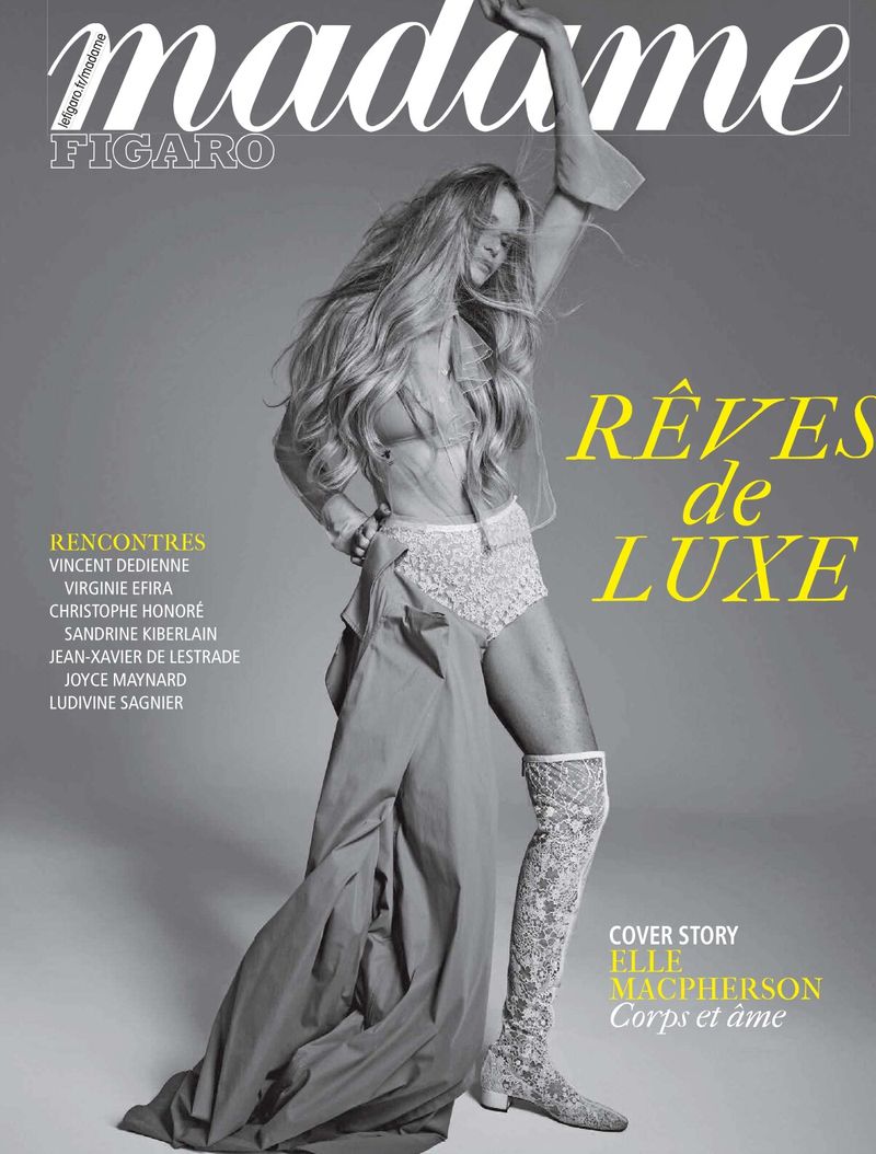 Elle Macpherson poses on a magazine cover in a lace bodysuit and high boots, set against a neutral gray backdrop, with magazine text.