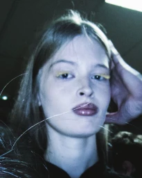 Close-up backstage portrait of a model with yellow eye makeup under cool cyan lighting at Ottolinger S/S 2026.