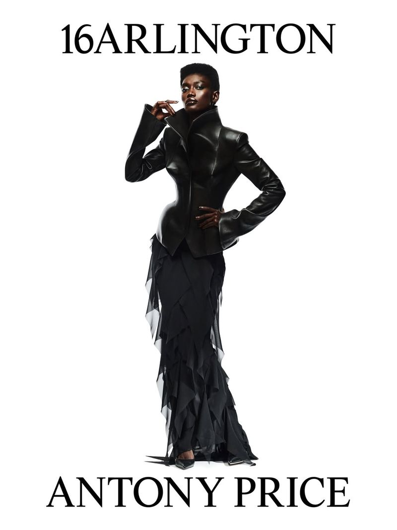 Elegant African American woman showcases a chic black leather jacket and layered skirt by 16 Arlington against a bright white backdrop.