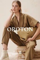 Model Vanessa Axente in a camel pantsuit holding a leather bag for Oroton Autumn Winter campaign