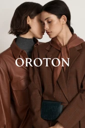 Two female models in brown outerwear posing close together against a plain background with the Oroton brand overlay.