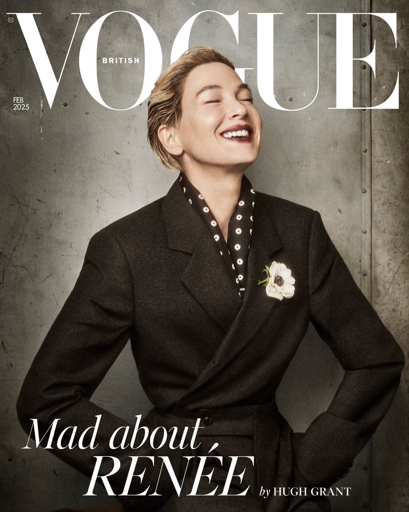 British Vogue cover featuring Reneé Zellweger in a dark suit with a floral brooch, smiling against a gray background, February 2025.