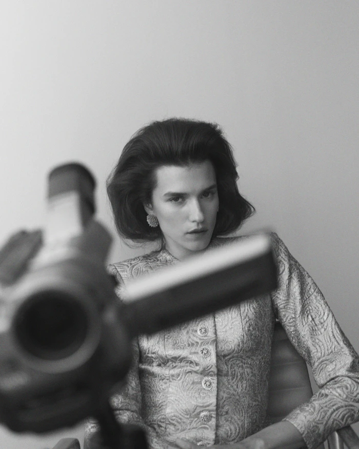 Model in patterned jacket with a vintage video camera in the foreground for Numero Netherlands Overtime