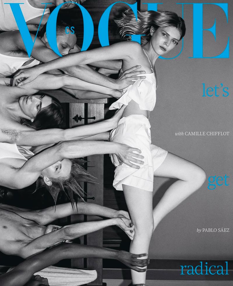 Vogue cover featuring a model in white attire, supported by a group of male figures and text overlays in blue on a grey background.