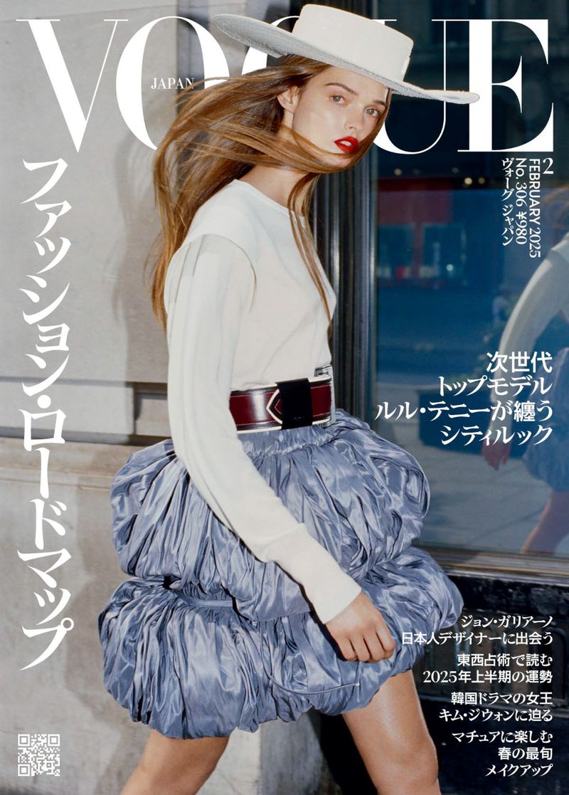 Vogue Japan cover featuring a long-haired woman in a white top and a large blue skirt, wearing a white hat against an urban backdrop.