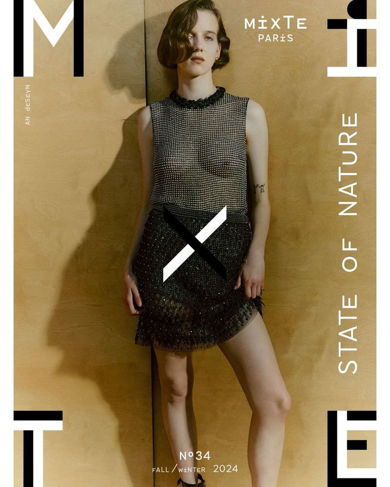 Fashion editorial magazine cover featuring a female model wearing a sparkly gray two-piece outfit on a wooden background.