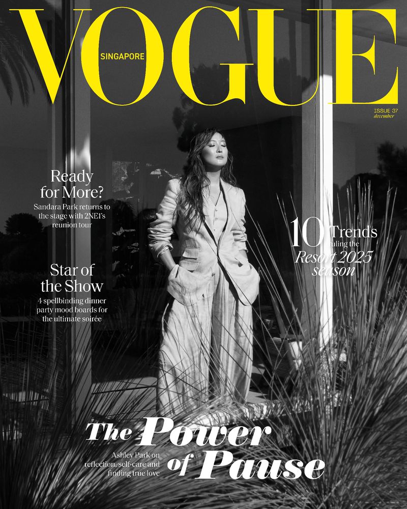 Vogue Singapore cover featuring Sandra Oh in a light-colored suit, posing outdoors among greenery. The magazine title is in large yellow letters.