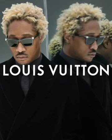 Portrait of a Black man with blonde hair wearing sunglasses and a black suit, next to a blurred reflection; Louis Vuitton logo is visible.