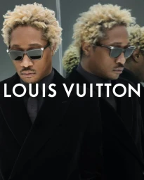 Rapper Future wearing dark sunglasses and a black tailored suit with blonde curly hair in a mirrored portrait for Louis Vuitton.