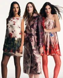 Three models posing in printed dresses and a patterned trench coat against a white studio background.