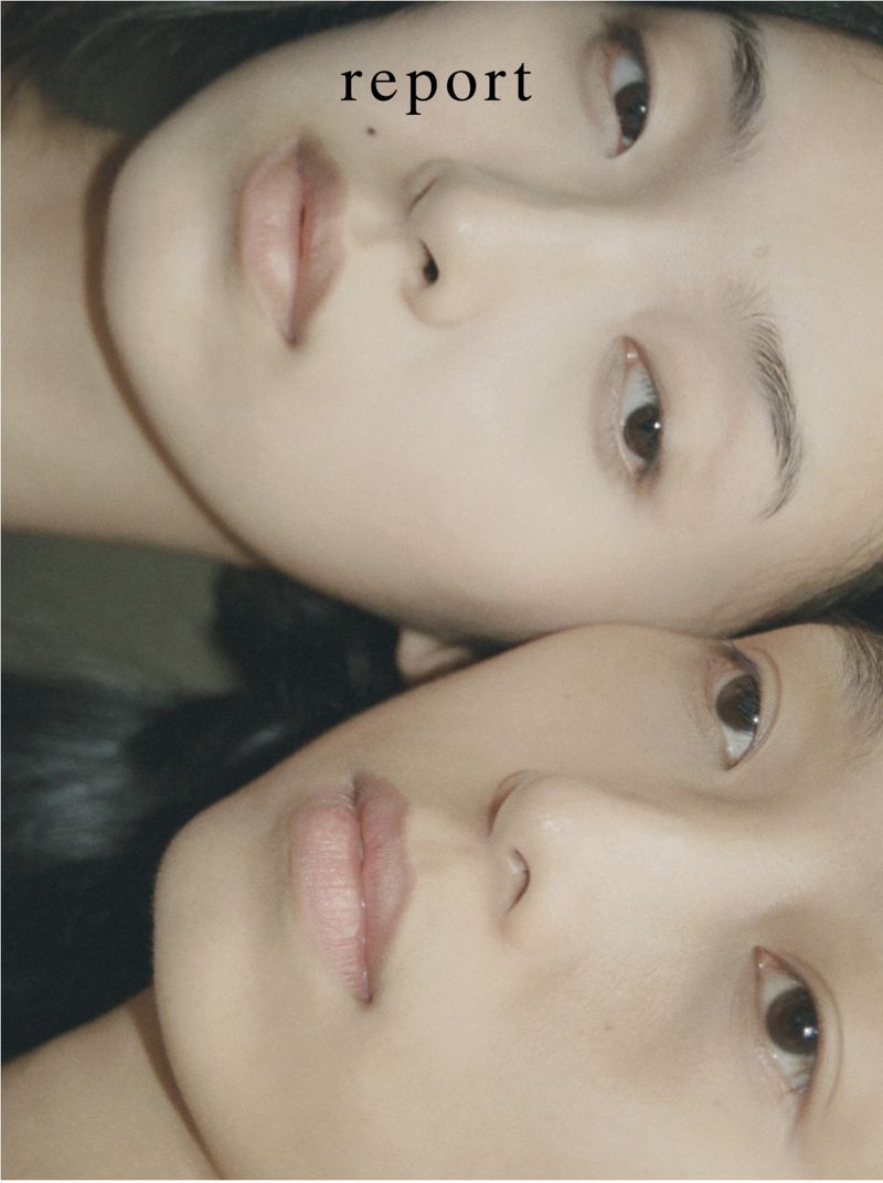 Close-up portrait of two Asian women with soft lighting; focus on their facial features and skin tones, with the word 'report' visible.