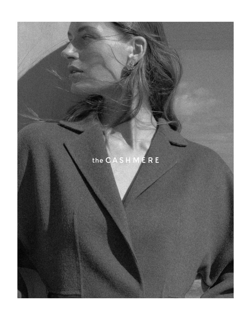 Black and white profile portrait of model Karlijn Kusters wearing a structured tailored coat under direct natural sunlight.
