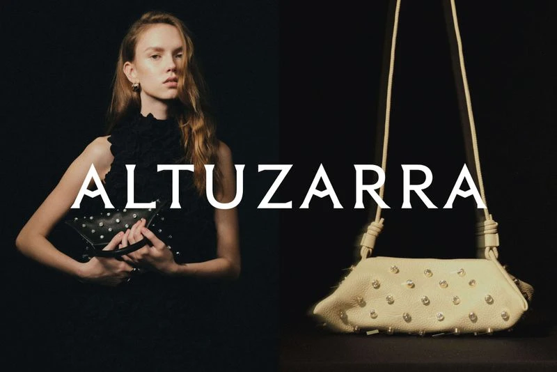 Fashion shot featuring a blond adult female in a black dress, holding a studded black handbag next to a studded beige handbag.