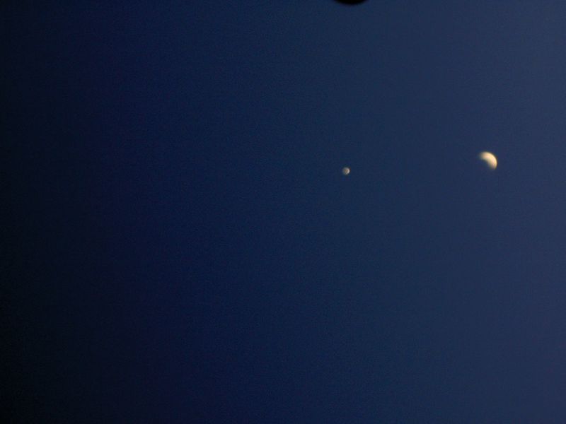 Wide shot of the night sky featuring two planets or stars visible against a dark blue background, showcasing celestial objects.