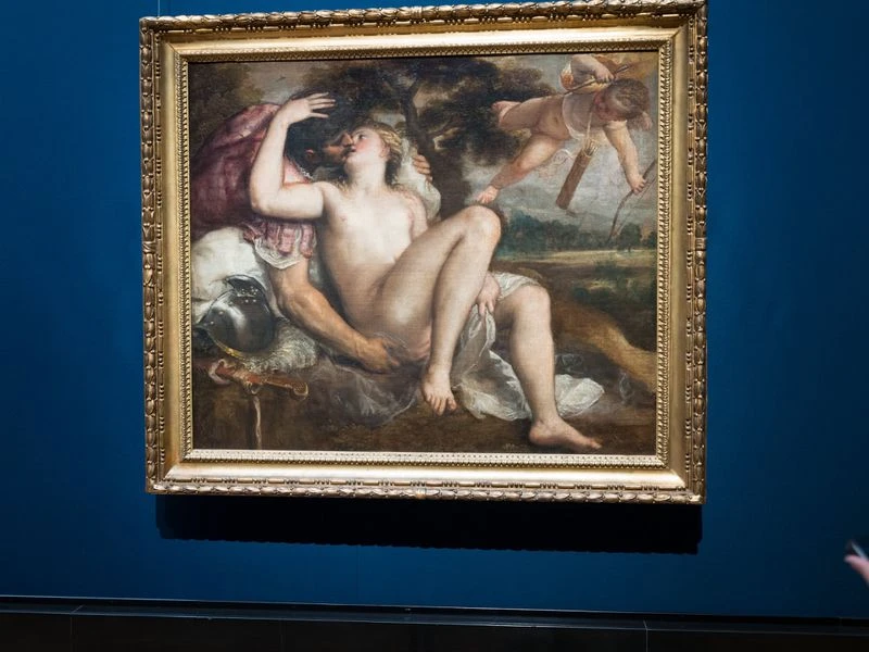 Framed oil painting depicts a nude woman reclining, embraced by a man in armour, with Cupid flying above, set against a green landscape.
