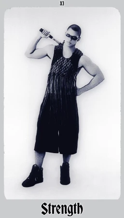 Monochrome portrait of a muscular adult male in alternative fashion holding a baton-like object, styled in a tarot card format.