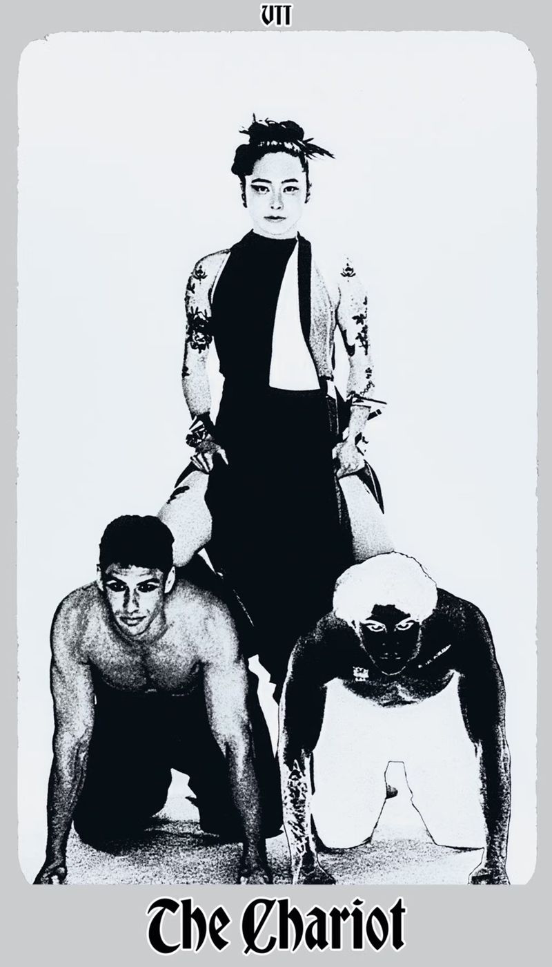 Tarot card image: A person stands atop two crawling figures in a monochromatic, vintage-style depiction of 'The Chariot' card.