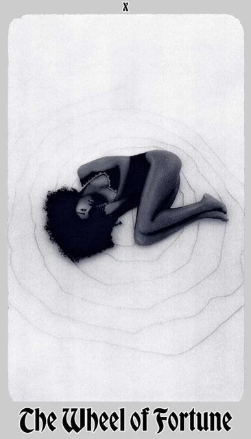 Monochrome image of a woman with afro lying on a surface with concentric circle patterns, resembling a tarot card aesthetic.