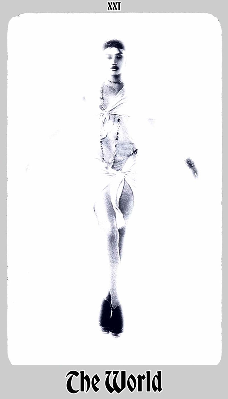 Artistic black and white image of an adult woman in a flowing dress, resembling a tarot card, against a bright white backdrop.