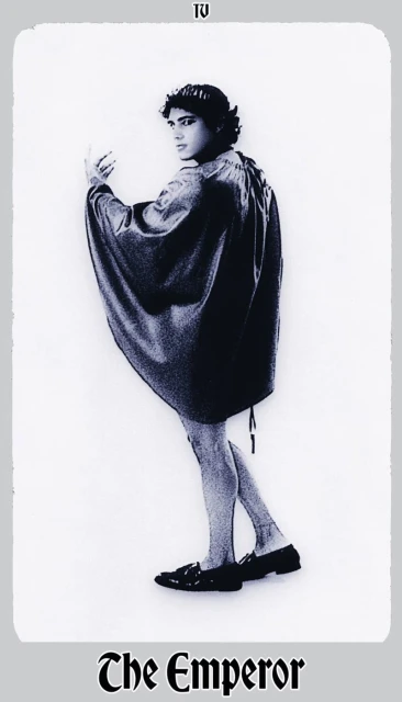 Full body shot of a male in dark tunic, pale legs, dark shoes; white gradient background; text 'The Emperor' below.