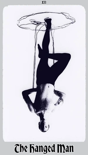 Black and white photograph styled as The Hanged Man tarot card, featuring a man suspended upside down against a white background.