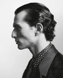 Black and white profile portrait of model Fares Ben M'barka wearing a polka-dot shirt and dark velvet tuxedo jacket.