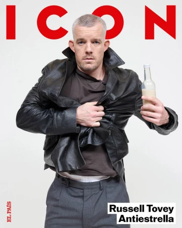 Magazine cover shot of Russell Tovey in a black leather jacket holding a bottle against a white background with red 'ICON' text.