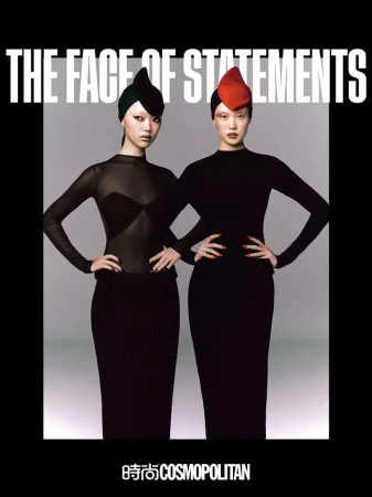 Editorial fashion shot of two Asian women in fitted black dresses and avant-garde hats posing in front of a soft grey backdrop.