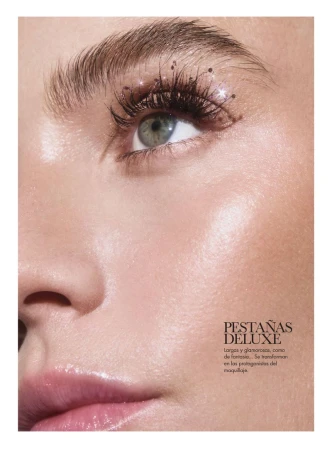 Close-up studio shot of a woman's face with makeup focusing on her eye, eyelashes, and eyebrow, with a soft, glowing complexion.