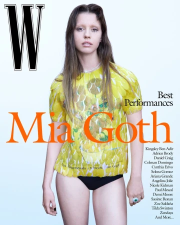 Mia Goth poses in a yellow floral top and black bottoms for W Magazine's Best Performances edition, with orange magazine text and brand logo.