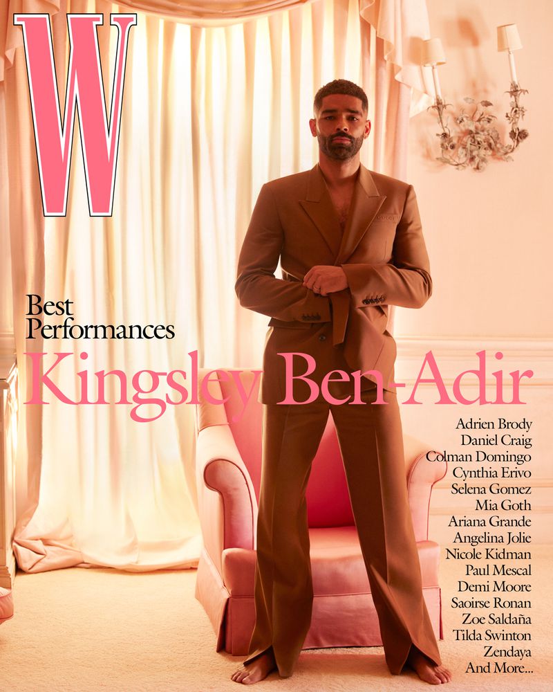 Kingsley Ben-Adir poses in a brown suit on the cover of W Magazine's Best Performances issue, beside a pink chair, set against a light pink backdrop.