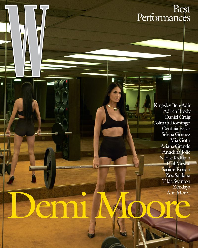 Magazine cover featuring Demi Moore in a gym setting, wearing a workout outfit and heels, posing with barbell weights and equipment.