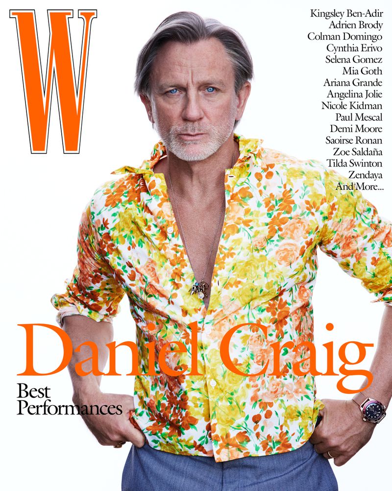 Daniel Craig gazes intensely in a medium shot, wearing a vibrant floral shirt and a wristwatch, with a white background and magazine text.