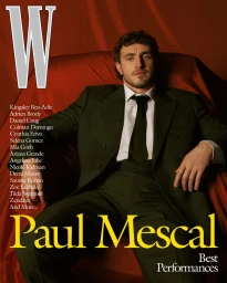 Actor Paul Mescal in a dark suit and tie seated against a draped red background for W Magazine Best Performances.