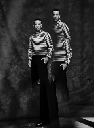 Black and white editorial portrait of Daddy Yankee wearing a striped turtleneck sweater with a double exposure effect.