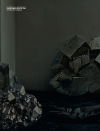 Moody editorial still life featuring textured mineral crystal formations and draped dark fabric against a dark grey studio background.