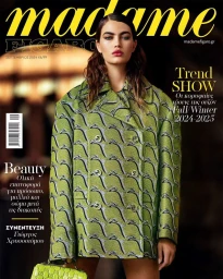 Model wearing a patterned green double-breasted coat and holding a matching green handbag for a magazine cover