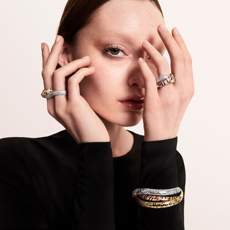 Model Avah Adams posing with diamond rings and stacked bracelets framing her face against a neutral studio backdrop.