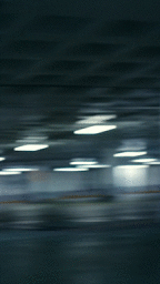 Motion-blurred view inside a parking garage with streak lines from overhead lights